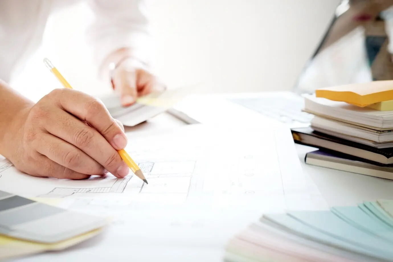 Grafikdesign sowie Farbmuster und Stifte auf einem Schreibtisch. Architektonische Zeichnung mit Werkzeugen und Zubehör.